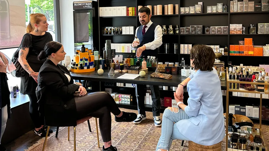 Man explaining products to seated women in store.