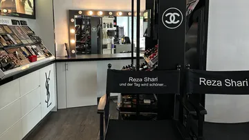 Make-up-Studio mit Stühlen und Spiegel.