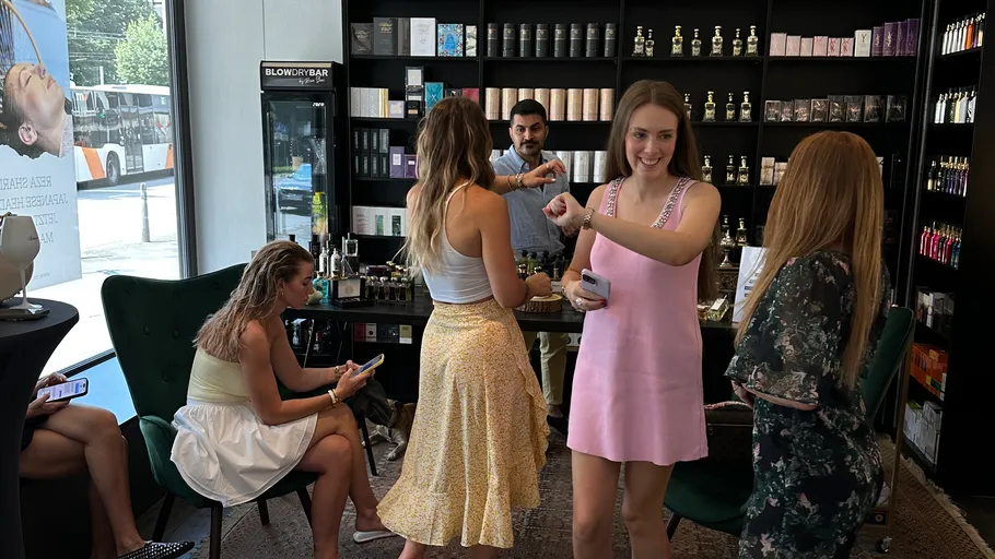Women trying perfume in a store setting.