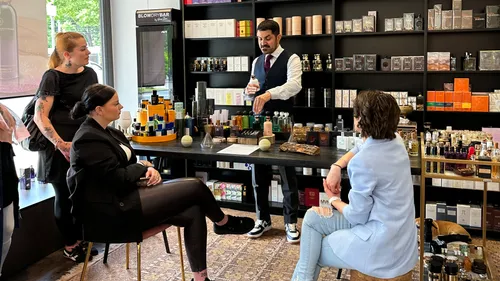 Drei Frauen beobachten Mann bei Produktvorführung im Laden.