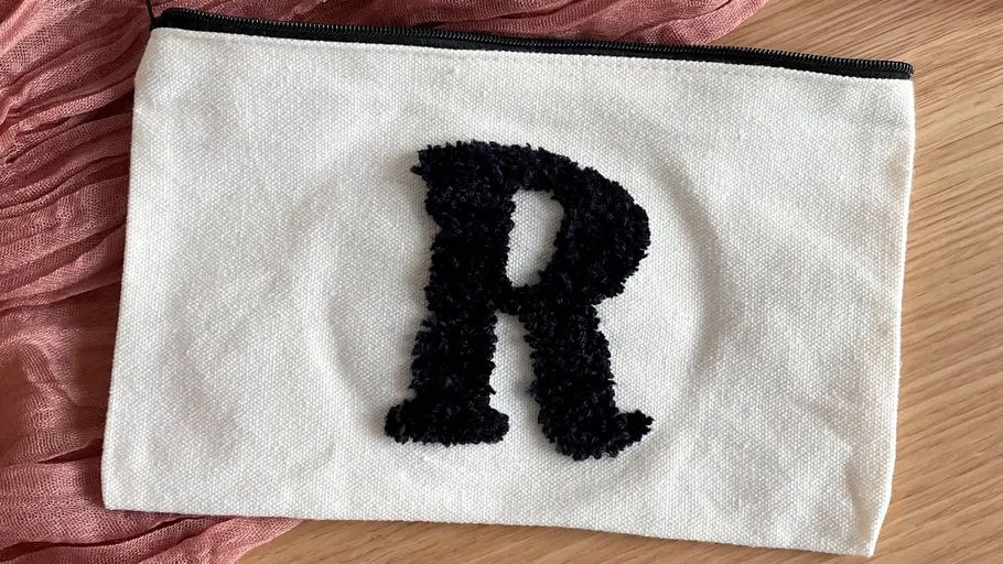 Weiße Tasche mit schwarzem Buchstaben R.