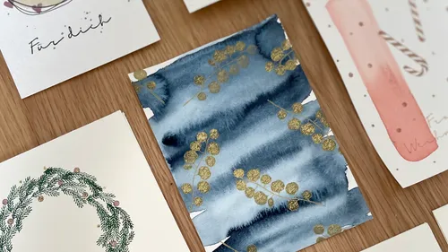 Künstlerische Karten mit Aquarellmustern auf Tisch.