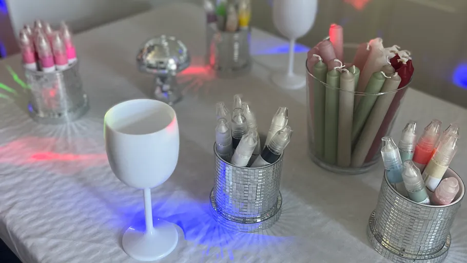 Table with markers, candles, goblets, disco lights.