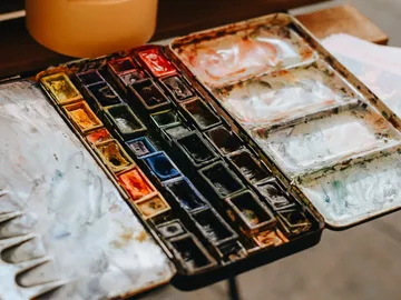 Farbenpalette mit verschiedenen Farbkasten auf einem Tisch.