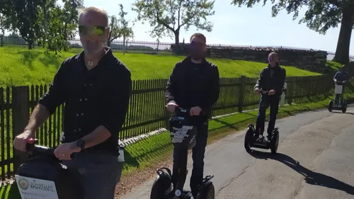 Gruppe fährt Segways auf sonnigem Weg.