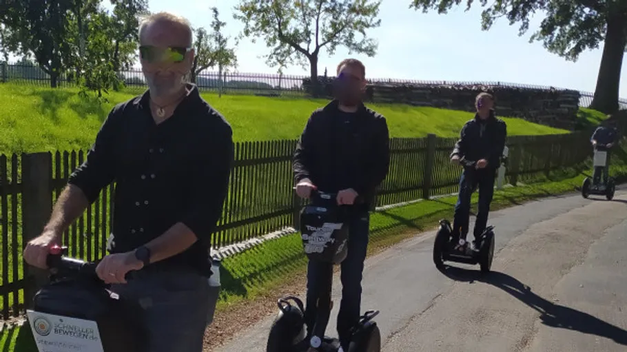 Gruppe fährt Segways auf sonnigem Weg.