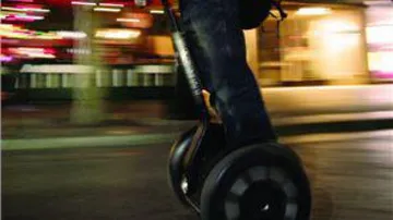 Person riding Segway on city street.