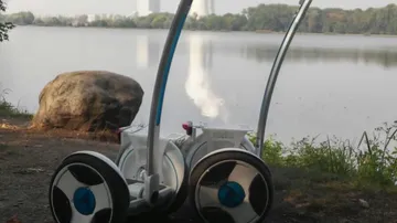Robot on pathway near a lake.