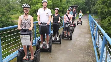 Gruppe fährt Segways auf einer Brücke.