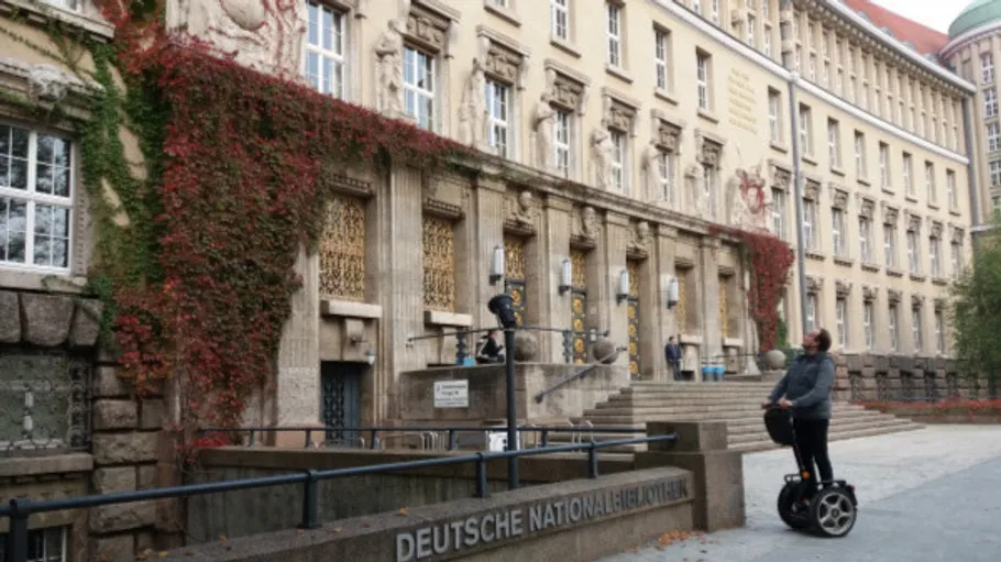 Person auf Segway vor historischer Bibliothek.