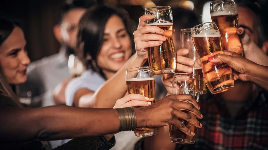 People clinking glasses in a bar.
