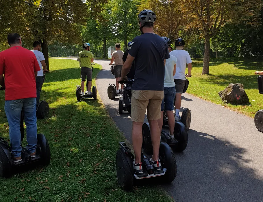 Menschen fahren Segways in einem Park.