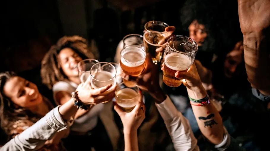 People raising beer glasses in celebration.