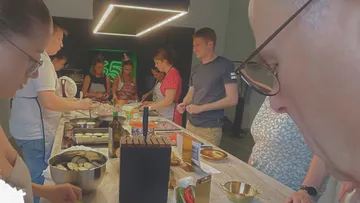 People cooking together around a kitchen island.