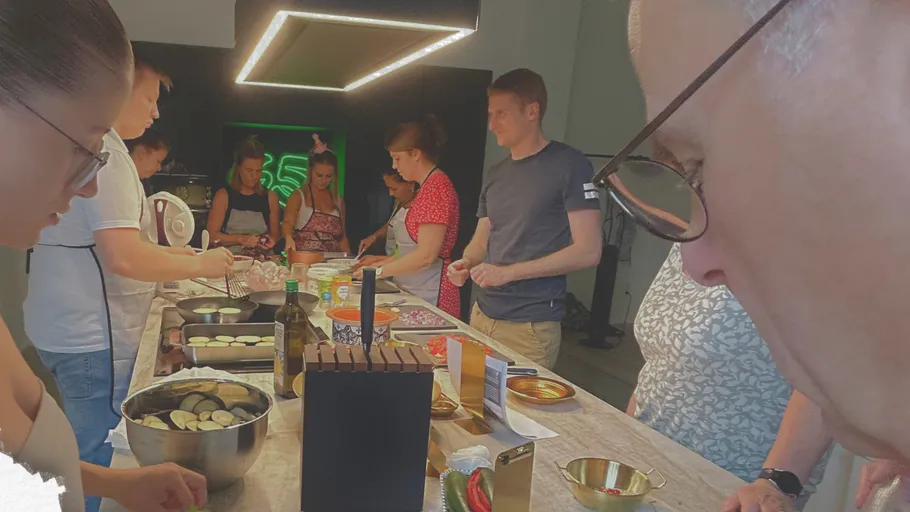 People cooking together around a kitchen island.