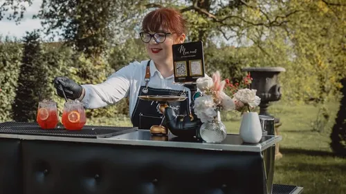 Woman serving drinks at outdoor event.