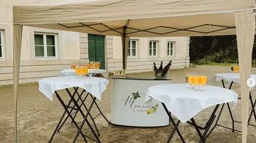 Getränkestand unter Pavillon vor Gebäude.