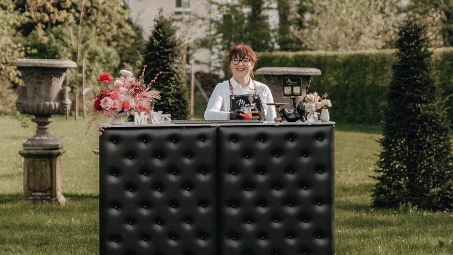Woman smiling behind a decorated outdoor bar.