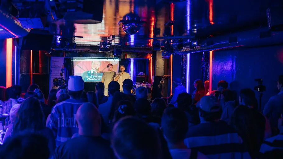 People watching comedians perform in a club.