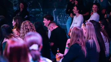 People laughing at a lively comedy show.