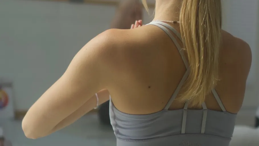 Woman in sports bra doing yoga indoors.