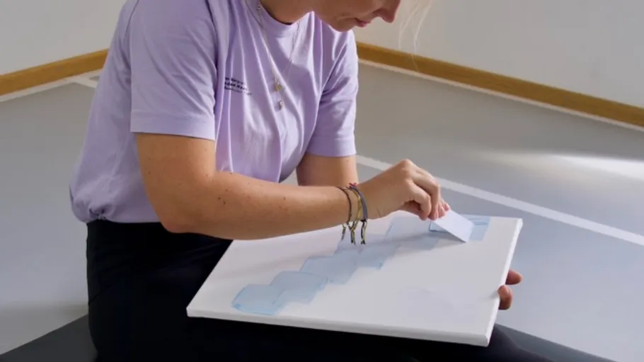 Person painting on canvas indoors.