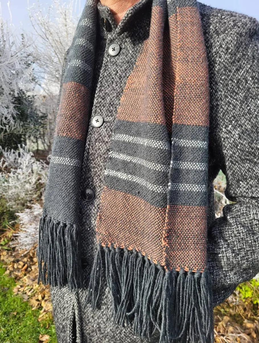 Person mit Schal und Mantel, winterlicher Hintergrund.