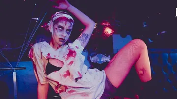 Person in zombie costume in a nightclub.