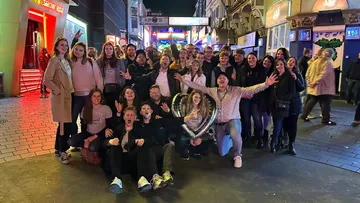 Group of people celebrating on lively street.