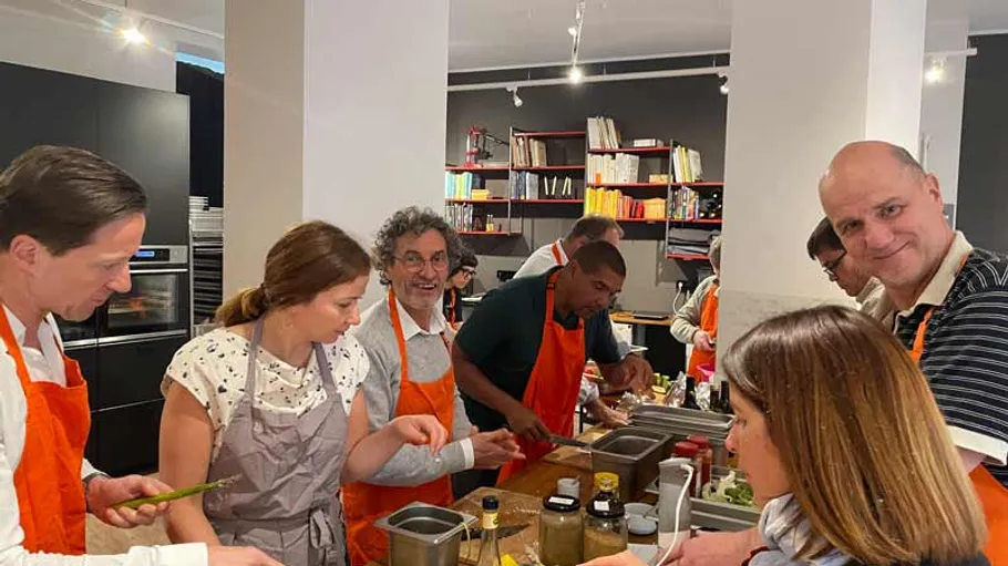 Menschen kochen gemeinsam in moderner Küche.