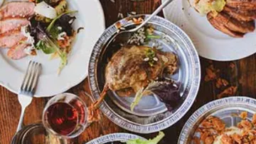Plates of gourmet food on wooden table.