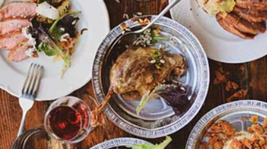Teller mit Gourmet-Essen auf Holztisch.