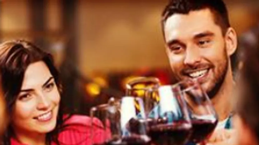 People smiling while toasting with wine glasses.