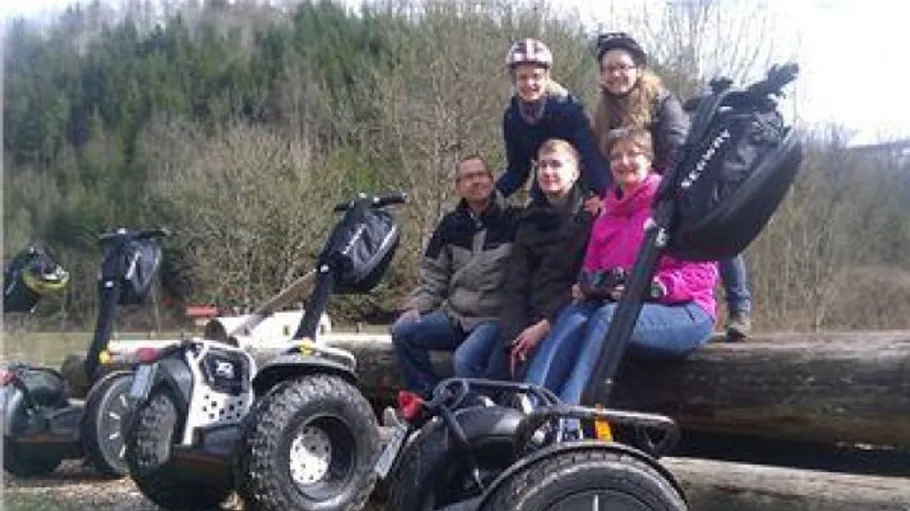 Gruppe sitzt mit Segways im Wald.