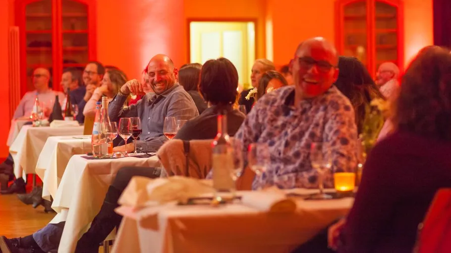 Menschen lachen, sitzen an Tischen im Restaurant.