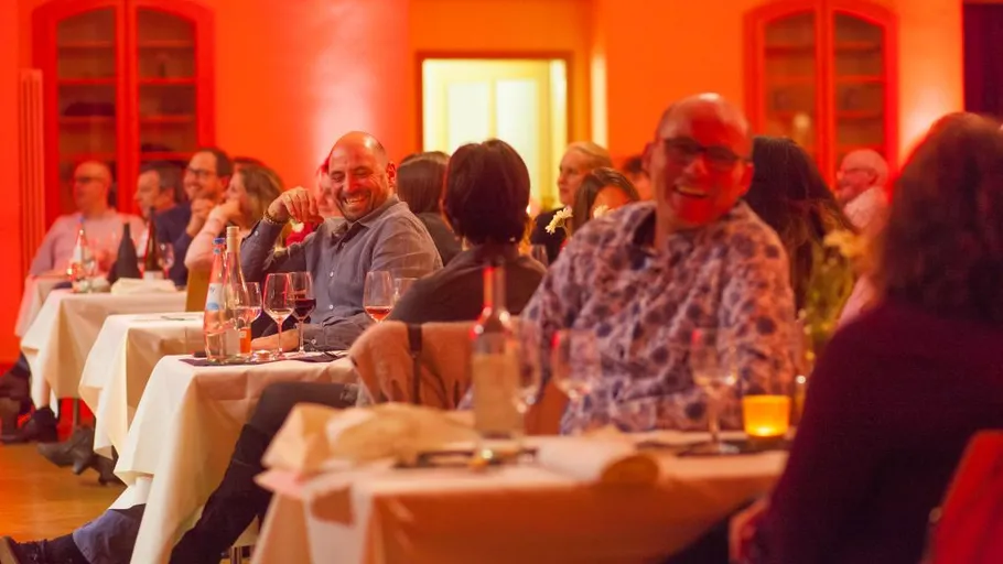 People sitting at tables in a dimly lit room.
