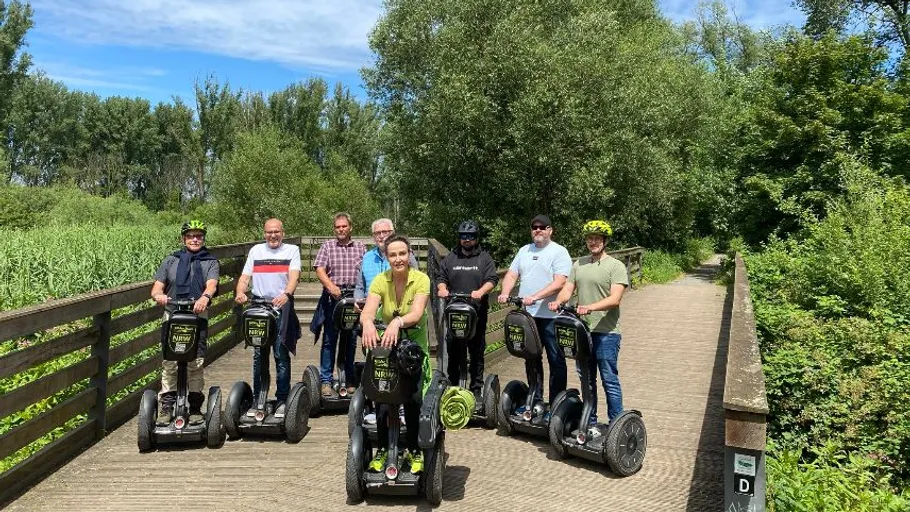 Gruppe auf Segways auf Holzbrücke.