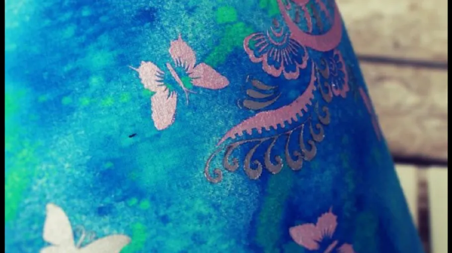 Fabric with ornate pink butterfly pattern.
