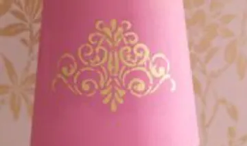 Pink lampshade with golden ornament design.