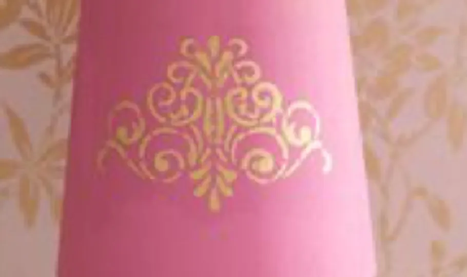 Rosa Lampenschirm mit goldenem Ornamentdesign.