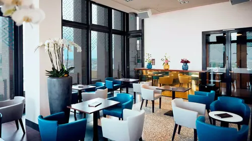 Modern cafe with colorful chairs and large windows.