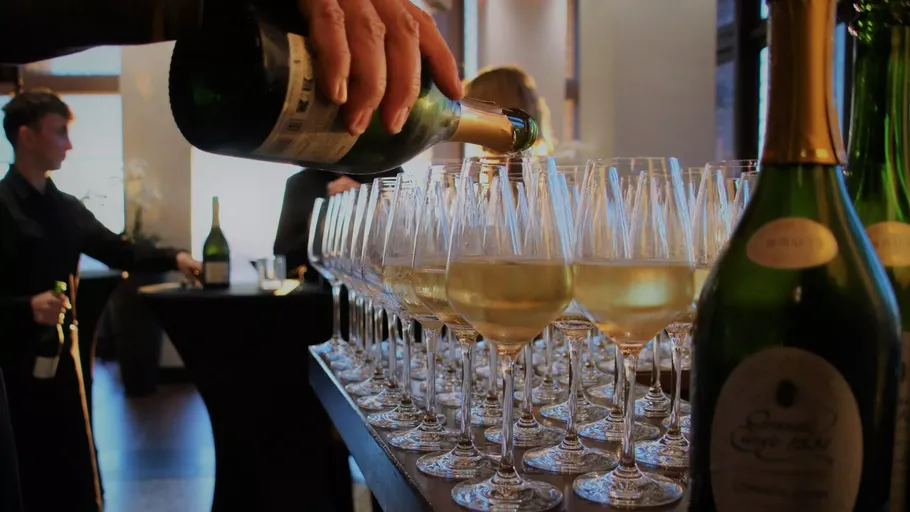 Champagne poured into glasses at an event.