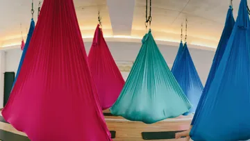 Colorful hammocks hanging in a room.