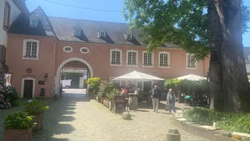 People walking in courtyard of historic building.