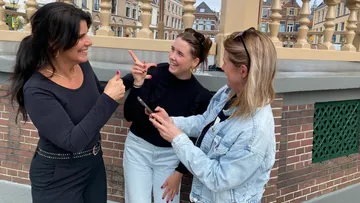 Drei Frauen unterhalten sich fröhlich im Freien.