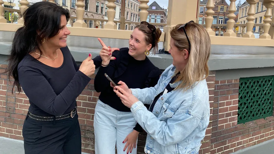 Drei Frauen unterhalten sich fröhlich im Freien.