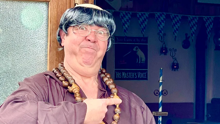 Mann im Kostüm zeigt, festlicher Hintergrund.