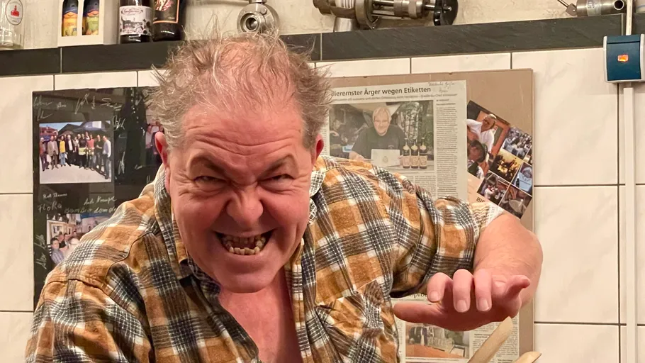 Man making a playful gesture indoors.