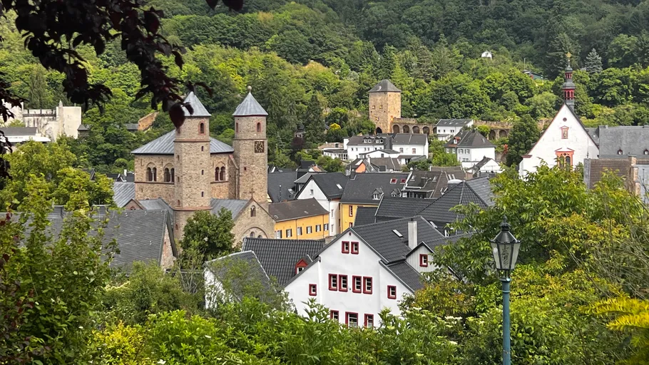 Dorf mit Kirche, umgeben von Bäumen.