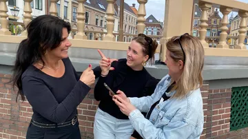 Three women talking and laughing outside.